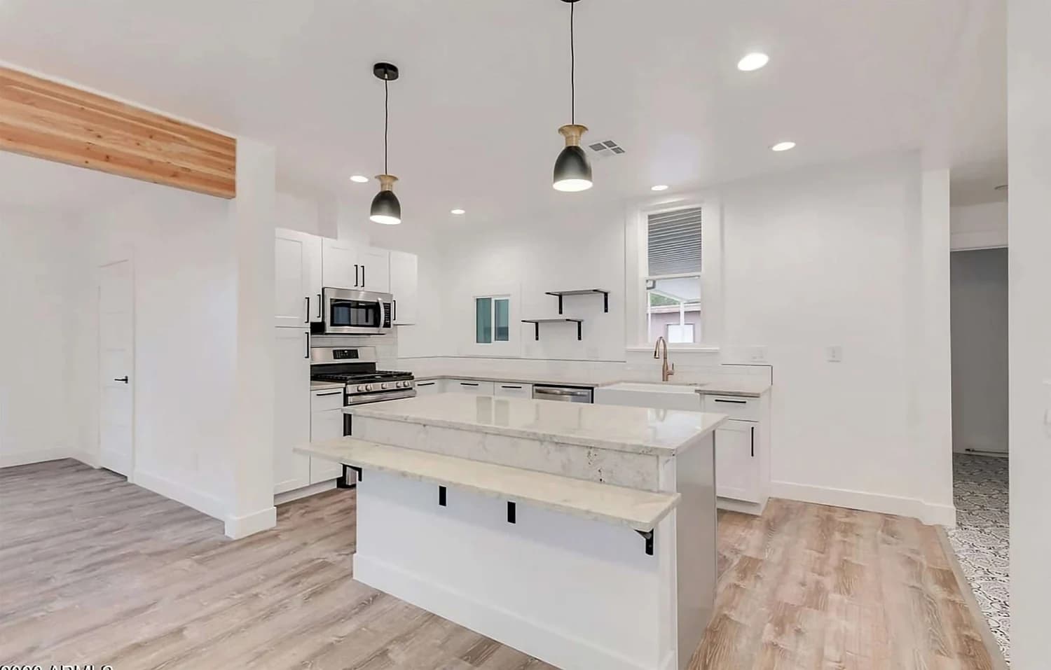 A bright kitchen with white painted cabinetry and walls